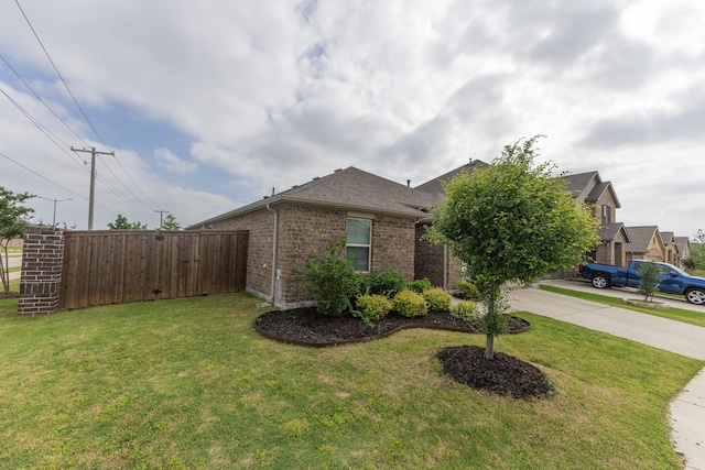 6000 Sutton Fields Trl, Celina, TX 76227 - view of side of property featuring driveway, roof with shingles, brick siding, fence, and a yard