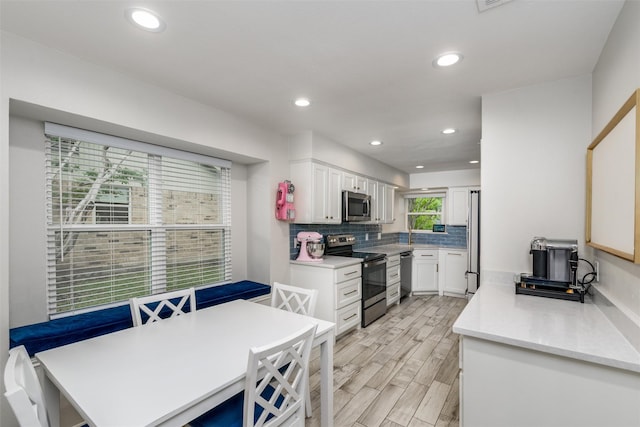 kitchen with recessed lighting, light countertops, white cabinetry, appliances with stainless steel finishes, and backsplash