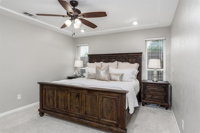 bedroom featuring baseboards, multiple windows, light colored carpet, and visible vents