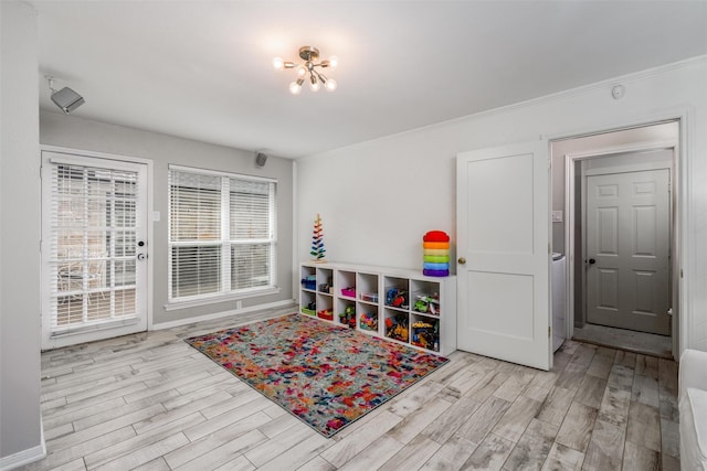 playroom featuring baseboards, wood finished floors, and a chandelier