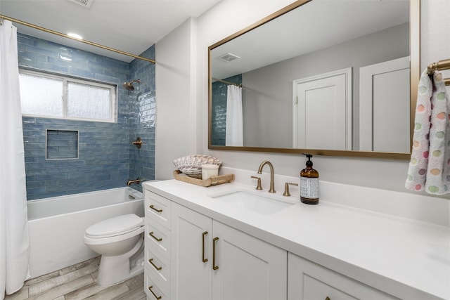 bathroom featuring visible vents, vanity, wood finished floors, toilet, and shower / bath combo