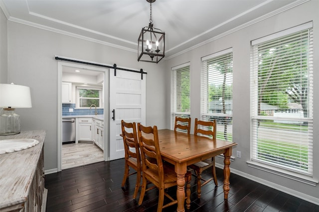 dining space featuring plenty of natural light, a barn door, dark wood-style flooring, and crown molding