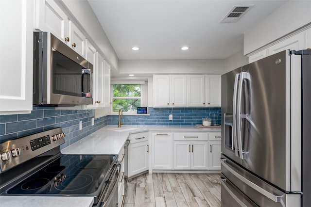 kitchen with visible vents, a sink, white cabinetry, and appliances with stainless steel finishes