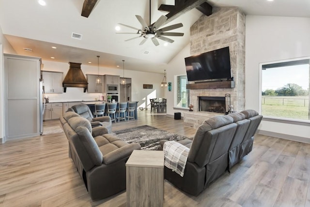 170 Rolling Hills Blvd, Alvord, TX 76225 - living area featuring visible vents, beamed ceiling, a stone fireplace, light wood-type flooring, and a ceiling fan