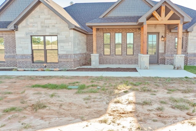 170 Rolling Hills Blvd, Alvord, TX 76225 - back of house featuring a shingled roof, stone siding, and brick siding
