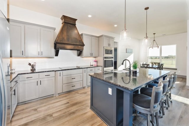 170 Rolling Hills Blvd, Alvord, TX 76225 - kitchen with a kitchen breakfast bar, appliances with stainless steel finishes, decorative backsplash, and custom range hood