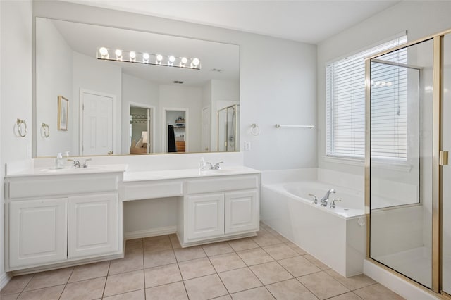 full bath with a sink, double vanity, a spacious closet, a garden tub, and a stall shower