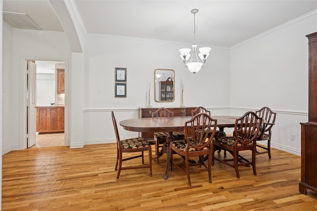 dining area with visible vents, ornamental molding, and light wood-style floors