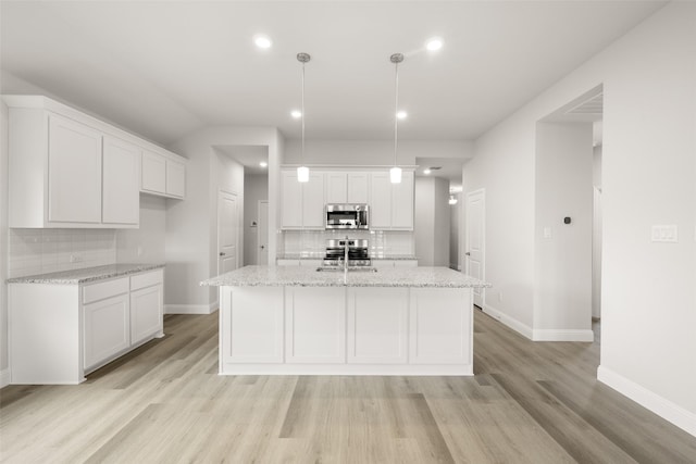 510 Reatta Dr, Justin, TX 76247 - kitchen with appliances with stainless steel finishes, tasteful backsplash, white cabinets, light wood-type flooring, and recessed lighting