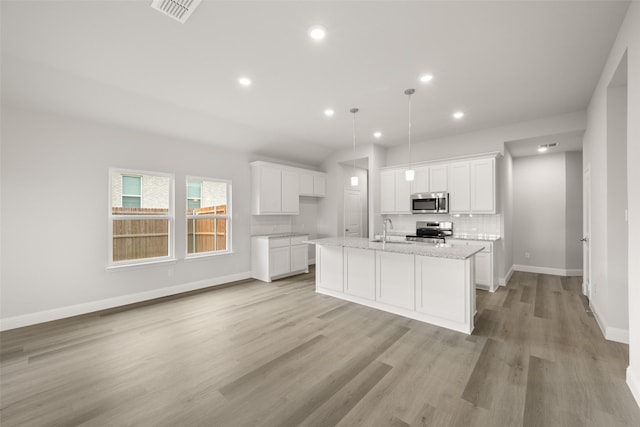 510 Reatta Dr, Justin, TX 76247 - kitchen featuring appliances with stainless steel finishes, light wood finished floors, white cabinetry, recessed lighting, and tasteful backsplash