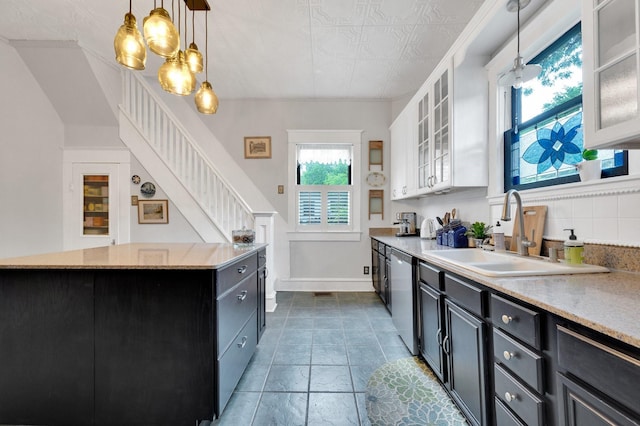 kitchen with dishwasher, a sink, baseboards, white cabinets, and dark cabinetry