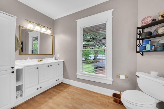 bathroom with crown molding, wood finished floors, a wealth of natural light, and toilet