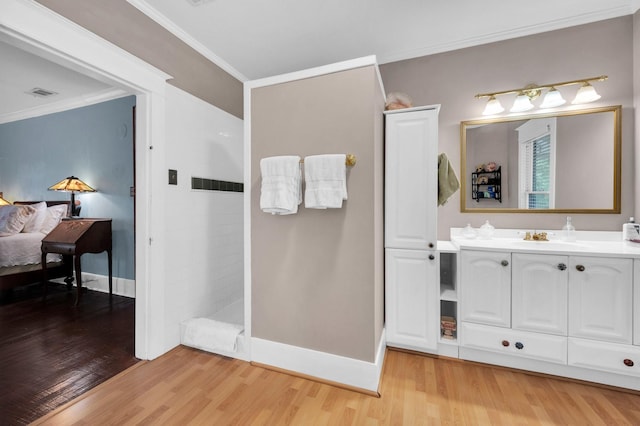 bathroom with walk in shower, ornamental molding, wood finished floors, and visible vents