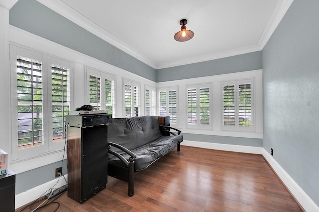living area with crown molding, a healthy amount of sunlight, and wood finished floors