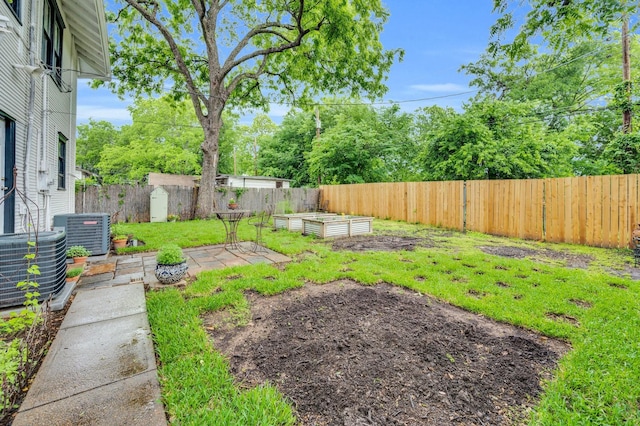 view of yard with a fenced backyard, cooling unit, and a garden