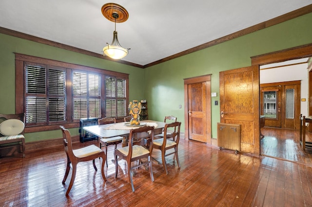 dining area featuring crown molding, baseboards, and hardwood / wood-style flooring