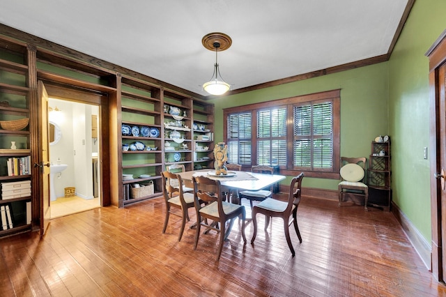 dining space with baseboards and wood finished floors