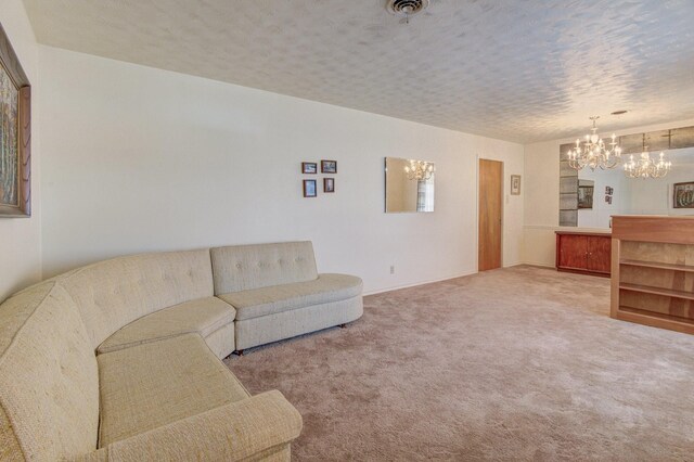 carpeted living area with visible vents and a chandelier