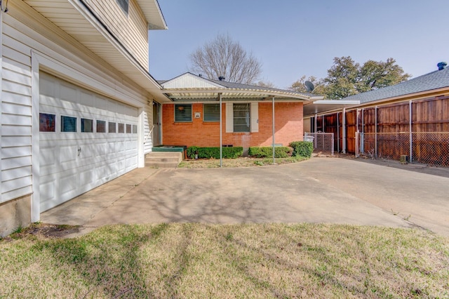 exterior space with fence, a garage, driveway, and brick siding
