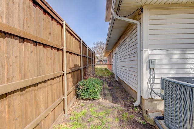 view of property exterior with central AC unit and fence
