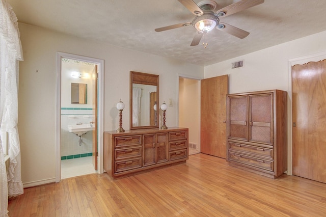 bedroom featuring baseboards, light wood-style flooring, visible vents, and a ceiling fan