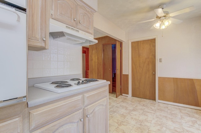 kitchen with under cabinet range hood, fridge, ceiling fan, white electric stovetop, and light countertops