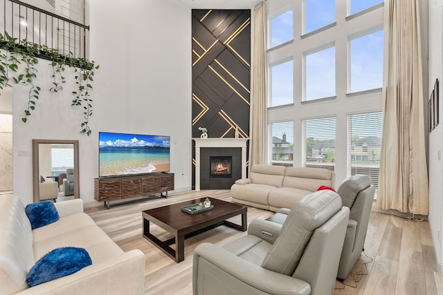 5617 Winona Ln, Mckinney, TX 75071 - living room featuring a high ceiling, light wood-style floors, and a large fireplace