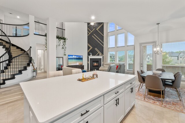 5617 Winona Ln, Mckinney, TX 75071 - kitchen featuring a chandelier, a high ceiling, white cabinets, healthy amount of natural light, and a center island