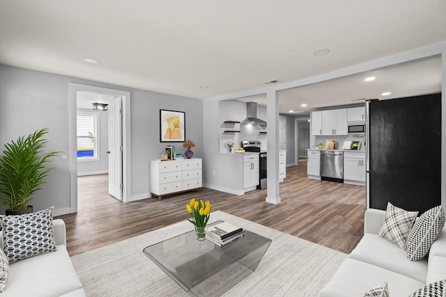 living area featuring recessed lighting, baseboards, visible vents, and wood finished floors