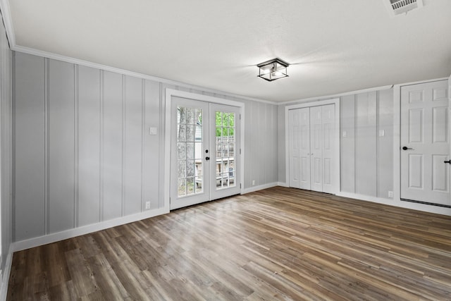 unfurnished bedroom with visible vents, a decorative wall, wood finished floors, and access to exterior