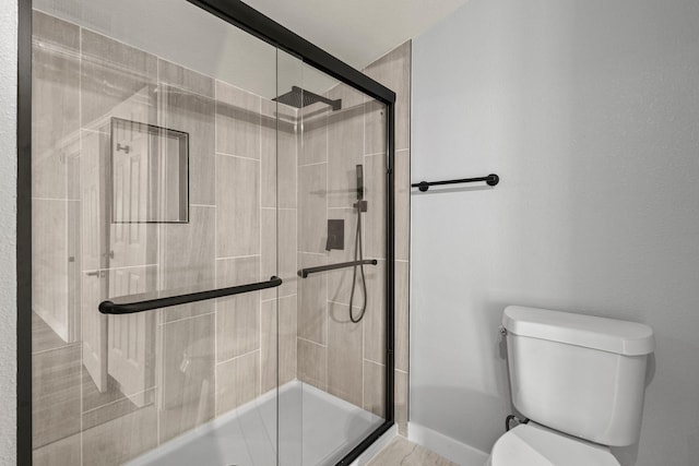 bathroom with a stall shower and toilet