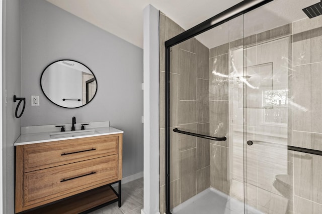 full bath with vanity, baseboards, and a stall shower