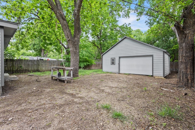 detached garage featuring fence