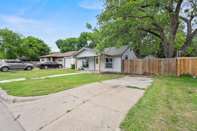view of front of home with fence, a front yard, and concrete driveway