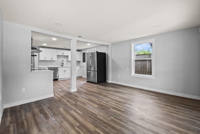 unfurnished living room featuring recessed lighting, baseboards, dark wood-style floors, and visible vents