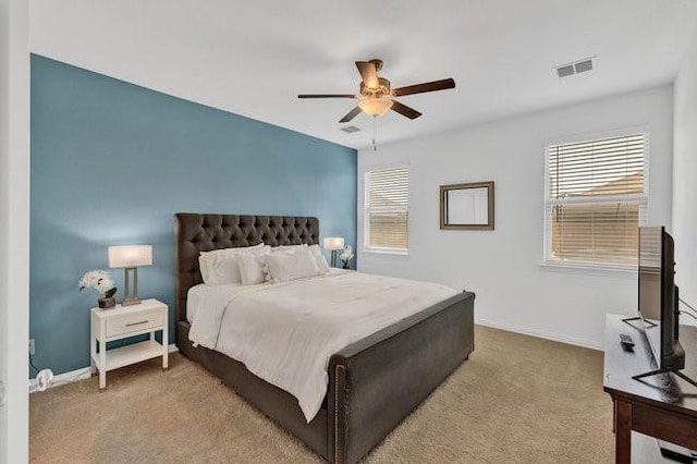 carpeted bedroom with baseboards, a ceiling fan, and visible vents