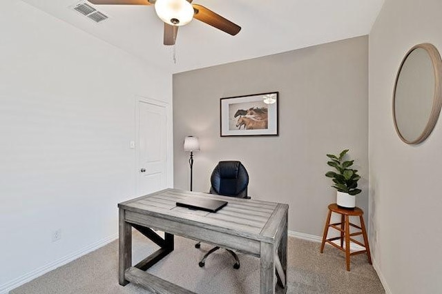 office with a ceiling fan, light colored carpet, visible vents, and baseboards