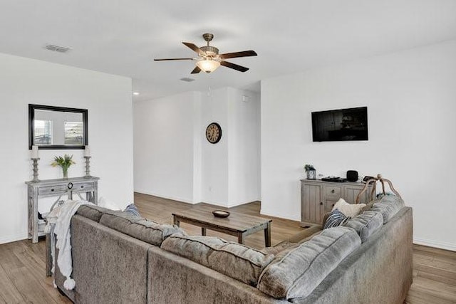 living room featuring a ceiling fan, visible vents, wood finished floors, baseboards, and recessed lighting