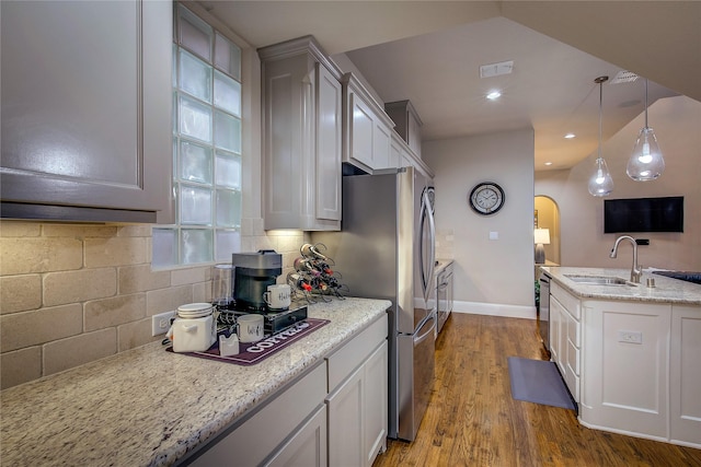 7401 Collin Mckinney Pkwy, Mckinney, TX 75070 - kitchen with a sink, baseboards, wood finished floors, stainless steel appliances, and decorative light fixtures