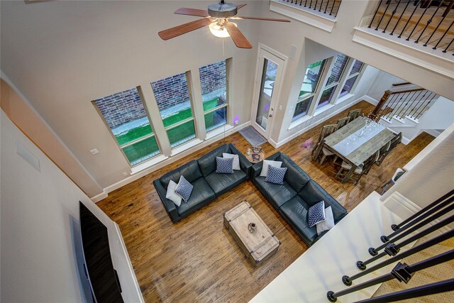 7401 Collin Mckinney Pkwy, Mckinney, TX 75070 - living area featuring a towering ceiling, ceiling fan, wood finished floors, and baseboards