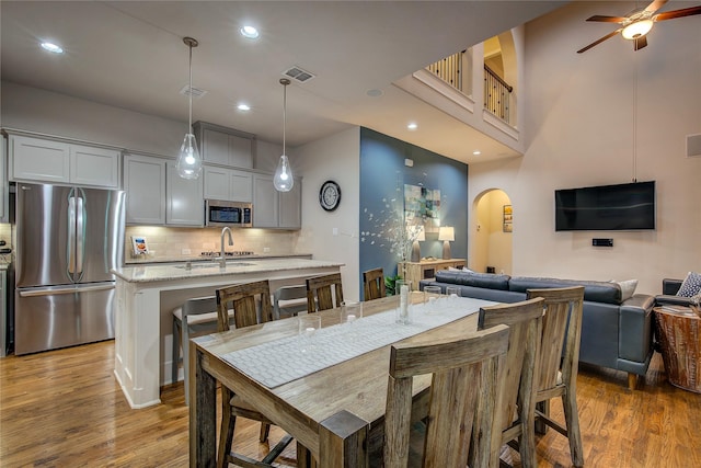 7401 Collin Mckinney Pkwy, Mckinney, TX 75070 - dining room with arched walkways, wood finished floors, ceiling fan, and recessed lighting