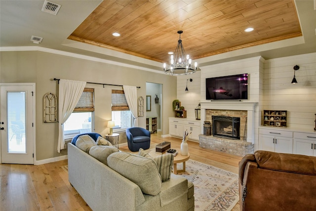 living area with a tray ceiling, visible vents, wood ceiling, and light wood-type flooring