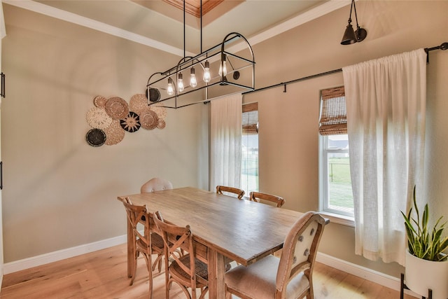 dining area featuring light wood-style floors, baseboards, and crown molding