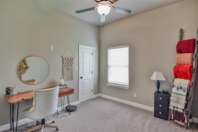 carpeted office featuring baseboards and a ceiling fan