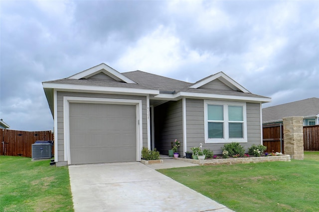 ranch-style house with fence, a front yard, concrete driveway, an attached garage, and central air condition unit