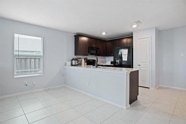 kitchen with visible vents, dark brown cabinets, light countertops, black appliances, and a peninsula