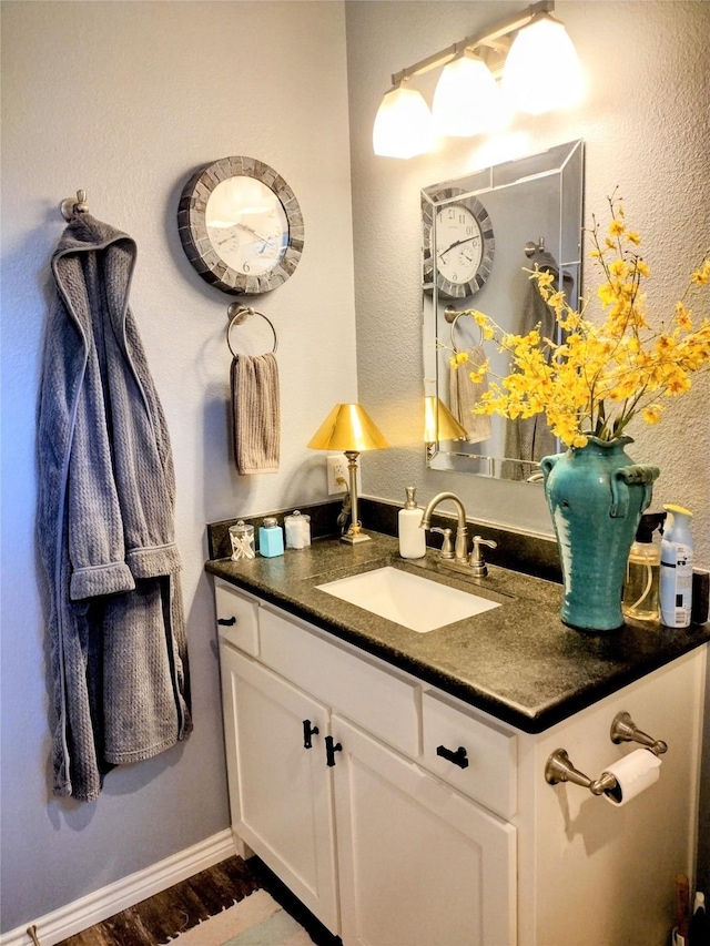 bathroom with vanity, baseboards, and wood finished floors