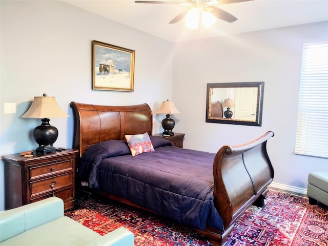 bedroom with ceiling fan and baseboards
