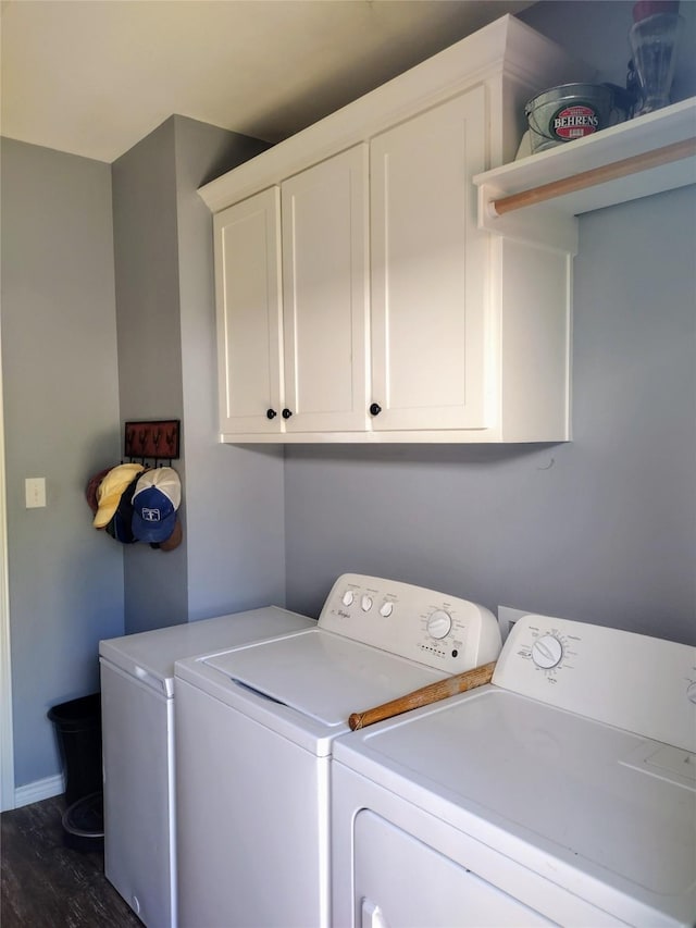 laundry room featuring baseboards, cabinet space, independent washer and dryer, and dark wood-style flooring