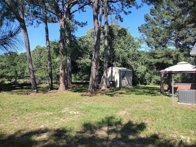 view of yard with a gazebo, a jacuzzi, a shed, cooling unit, and an outdoor structure